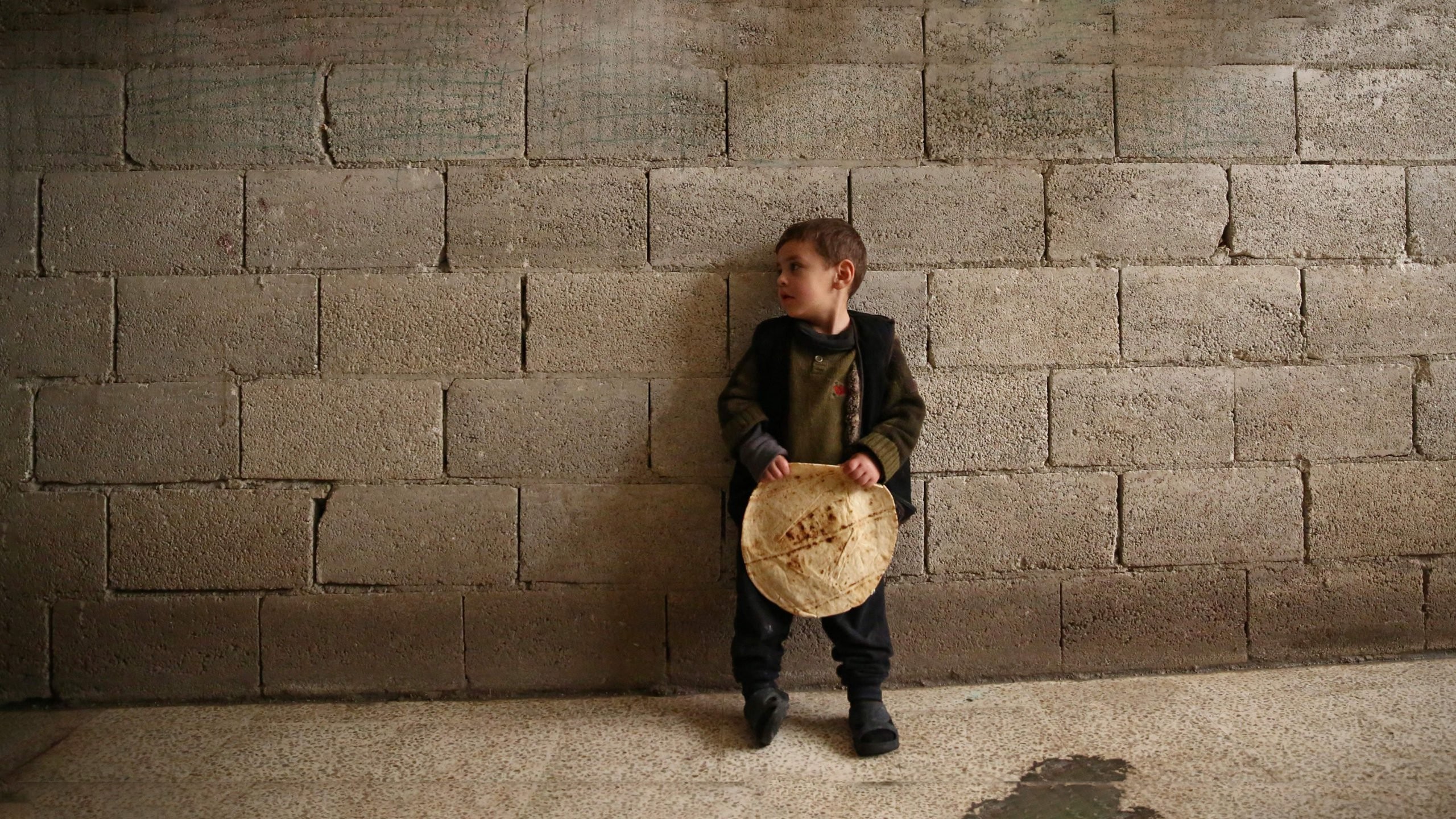 طفل يحمل رغيف خبز (إنترنت)