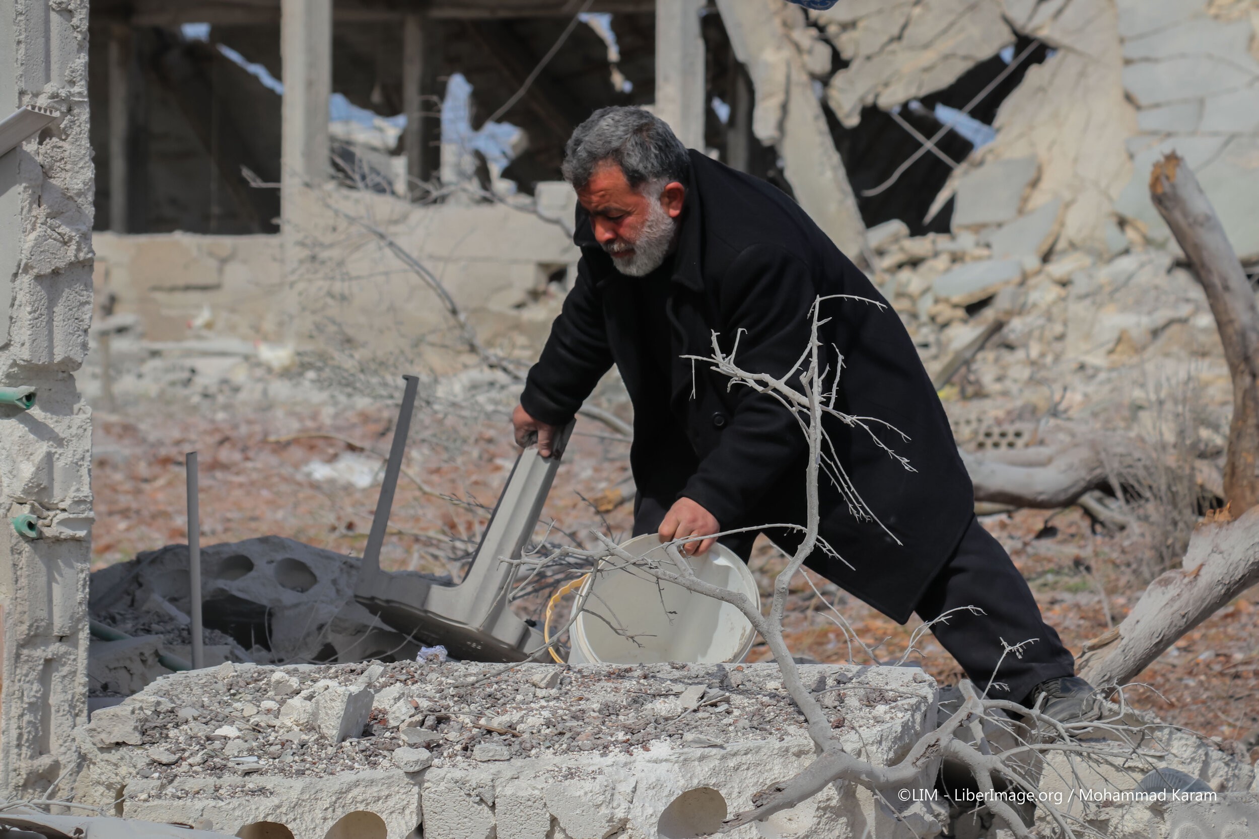 رجل سوري يبحث في أنقاض بيته بعد قصف طائرات النظام
