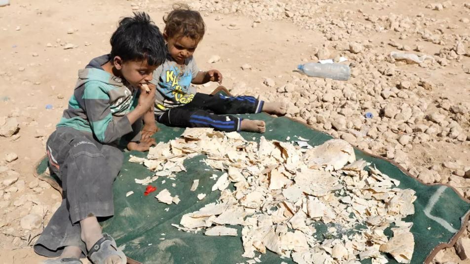 صورة تعبيرية لطفلان يأكلان كسرات الخبز اليابس (إنترنت)