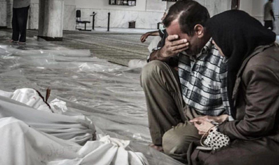 والدين يودعان أطفالهم الذين قضوا بهجوم كيماوي لنظام الأسد (إنترنت)