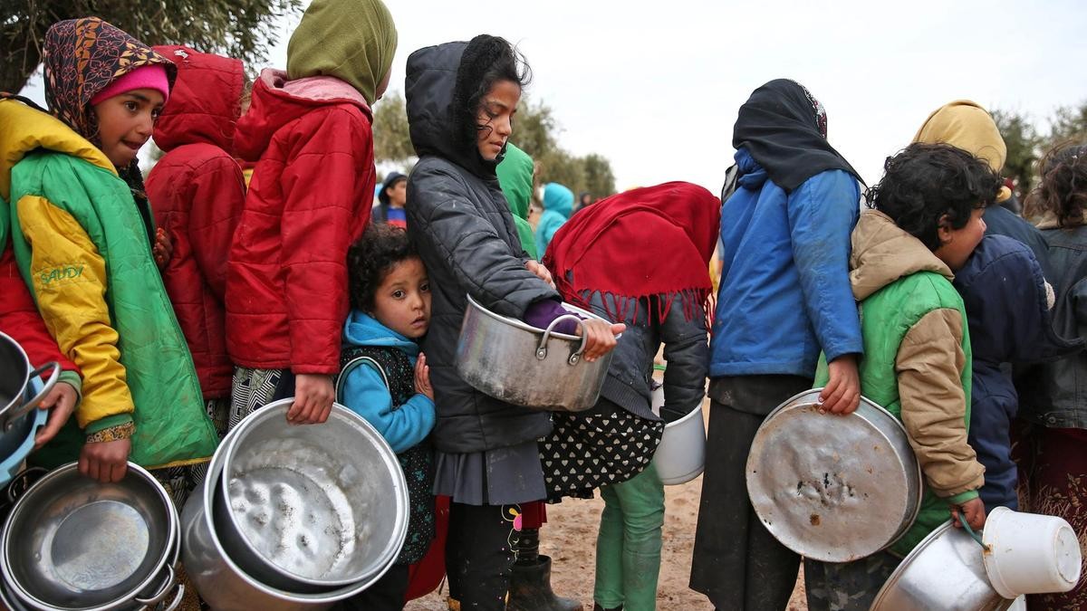 أطفال سوريون  يصطفون لتلقي حصص غذائية