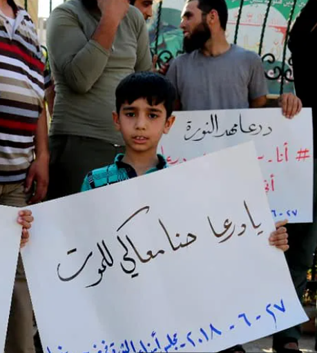 طفل يحمل لوحة يا درعا حنا معاكي للموت(منبج، انترنت)