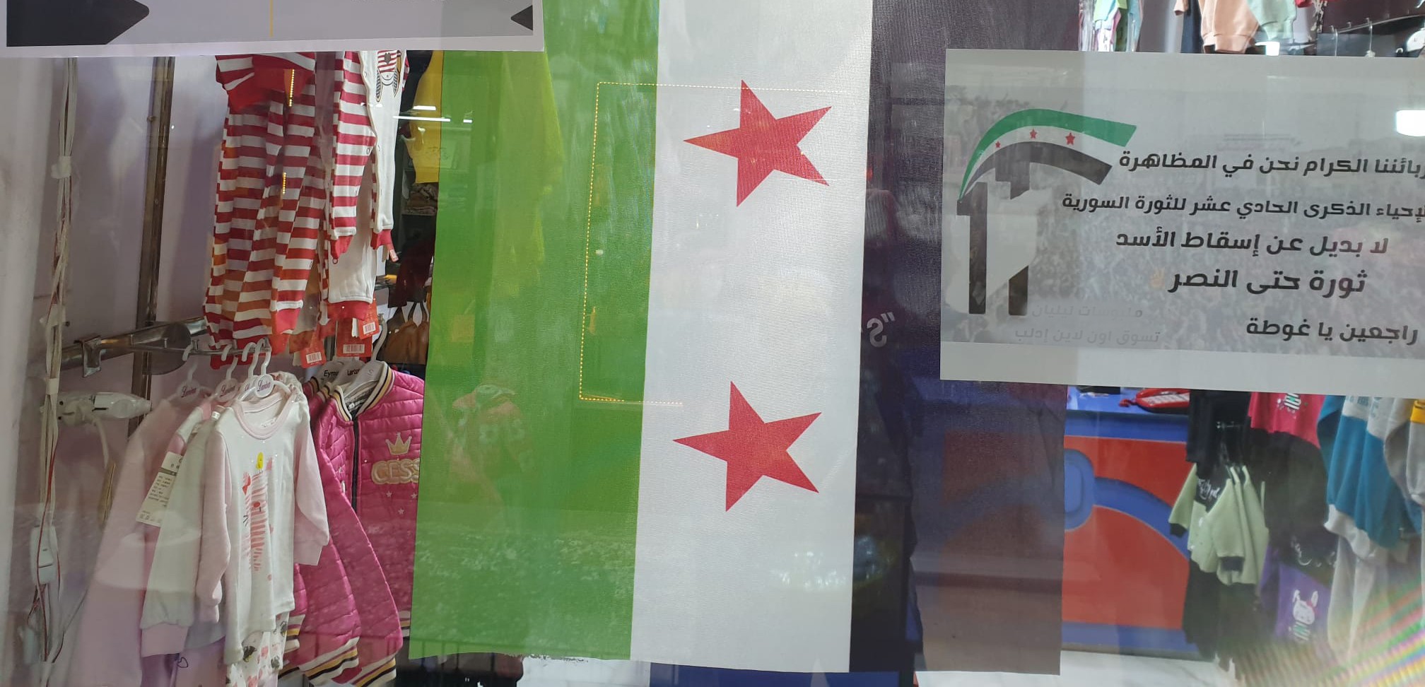 واجهة محل تجاري في الشمال السوري يرفع علم الثورة (السوري اليوم)
