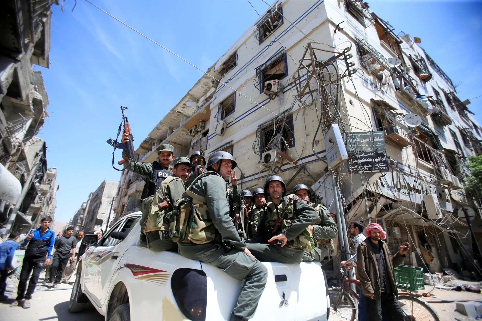 صورة لقوات الأسد وبجانبهم آثار الدمار (انترنت)