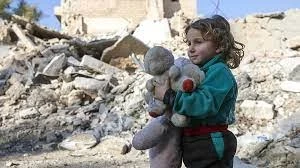 طفلة سورية تحمل لعبتها في مخيم للاجئين