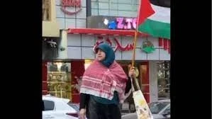إمرأة مصرية ترفع علم فلسطين وترتدي الكوفية وسط القاهرة