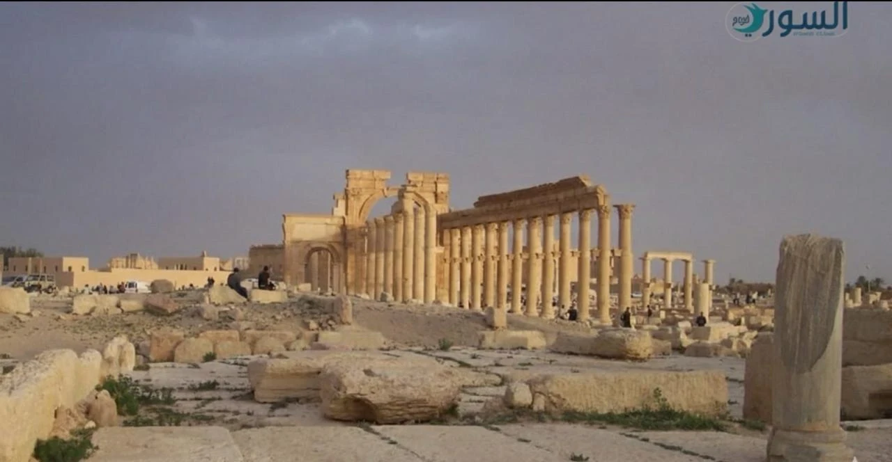 صورة أرشيفية للشارع الرئيسي المُعَمَّد وقوس النصر في مدينة تدمر، التُقطت عام 2009 قبل اندلاع الثورة السورية وما شهدته المدينة لاحقًا من دمار وتغيّرات تاريخية.